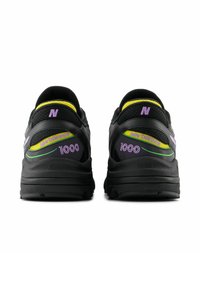 Baskets en maille noire et synthétique avec des accents violets, jaunes et verts. Présentent les marques "new balance" et "1000" sur les côtés.