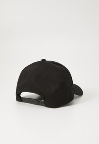 Gorra de béisbol de algodón negro con visera curva y correa de plástico ajustable en la parte posterior. Presenta ojales bordados para ventilación.