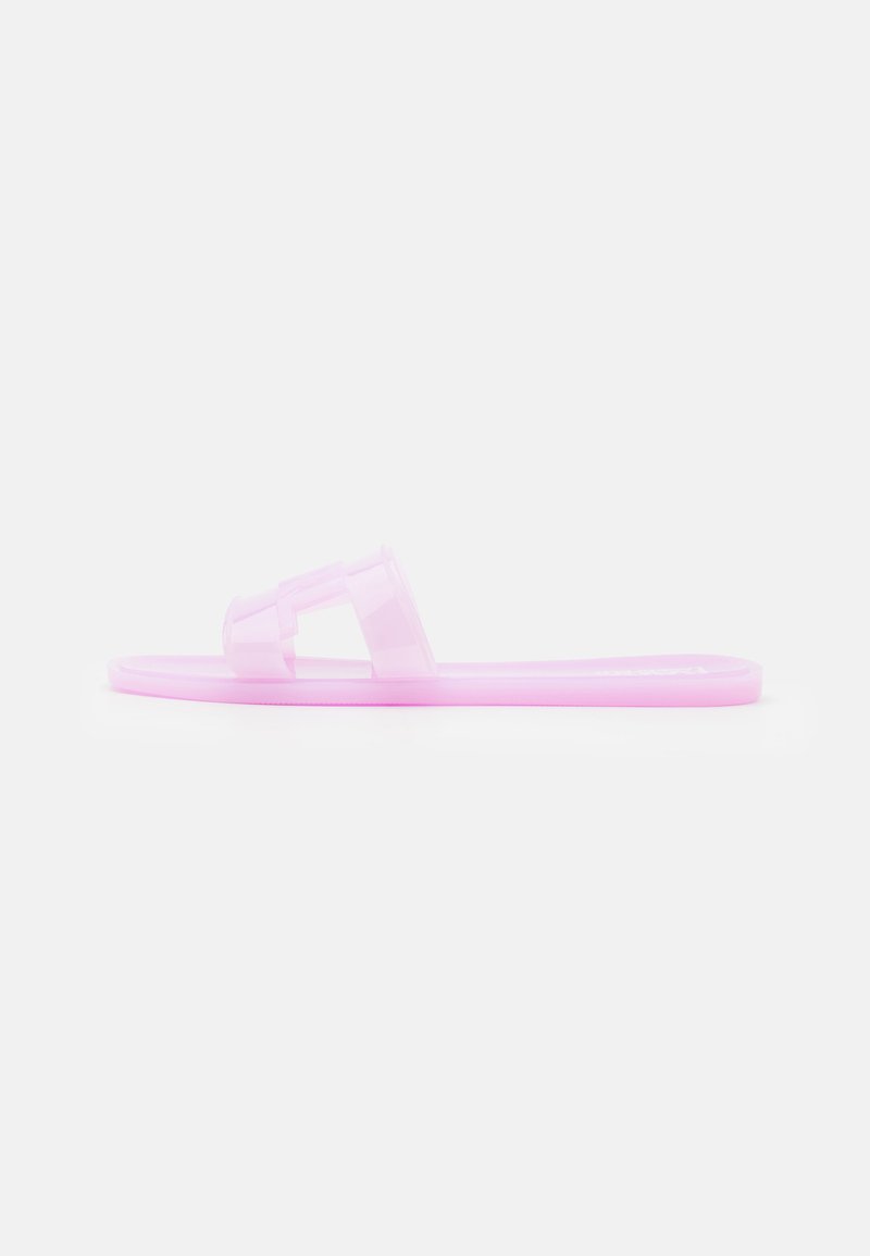 Rosa transparent flip-flop med platt sula och en bred rem med geometriska utskärningar. Slät textur och minimalistisk design.