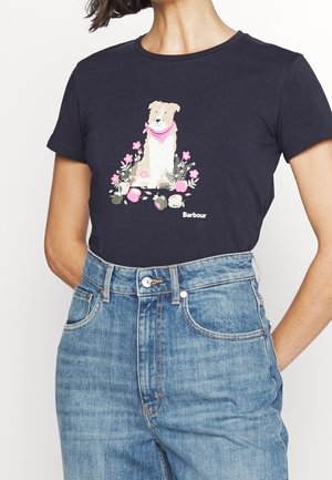 Marineblauw T-shirt met een hond die een roze bandana draagt, omringd door roze bloemen, gecombineerd met hooggetailleerde blauwe jeans.