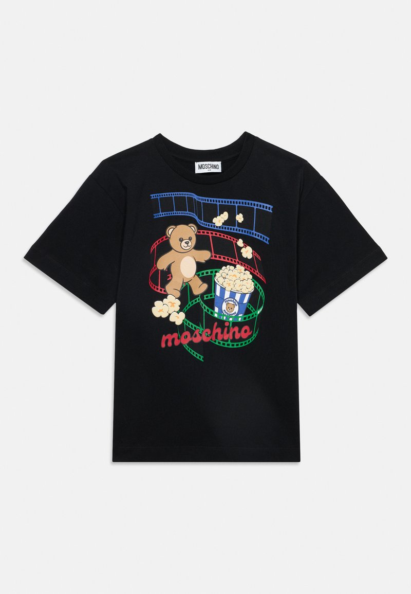 Μαύρο t-shirt Moschino με πολύχρωμες φιλμ ταινίες, μια αρκούδα teddy, ποπ κορν και τη λέξη Moschino με κόκκινα γράμματα μπροστά.