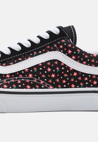 Baskets en toile noire avec lacets blancs et bande latérale, arborant un motif floral en rouge et rose sur fond noir. Semelle en caoutchouc.