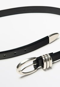 Zwarte leren riem met een glanzende zilveren ovale gesp, drie ronde accenten nabij de gesp, en gelijkmatig verdeelde gaatjes langs de band.