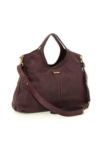 Borsa a mano in pelle marrone con doppi manici, tracolla lunga removibile e hardware dorato su uno sfondo bianco.