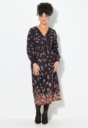 Schwarz gemustertes Wickeldress mit langen Ärmeln, das eine geraffte Taille, zarte rosa und grüne Blumenmuster sowie einen fließenden Saum aufweist.