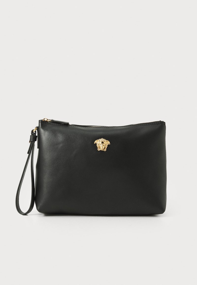 Must mustrasskott must koos kuldse Medusa sümboliga, lukuga sulgumine ja eemaldatav rihm, sileda tekstuuri ja ristkülikukujuga.