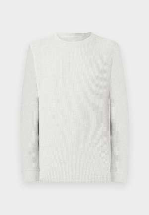 Langärmliges, hellgraues Waffelstrick-Shirt mit Rundhalsausschnitt, gerippten Bündchen und strukturierter Stoffstruktur vor einem einfarbigen Hintergrund.