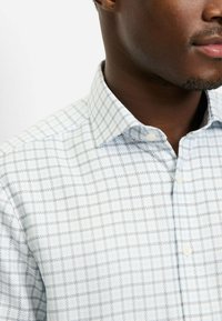 Kariertes Hemd zum Knöpfen in Hellblau und Grau. Hergestellt aus Stoff mit glatter Textur und klassischem Kragen.