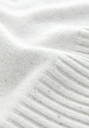 White knitted fabric featuring a soft texture with a combination of smooth and ribbed patterns. Subtle flecks are visible throughout.