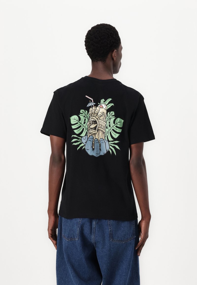 Zwart katoenen T-shirt met een kleurrafische afbeelding van een hand die een drankje vasthoudt, omringd door groene bladdesigns op de achterkant.