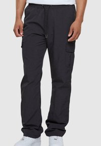 Black cargo pants with an elastic waistband and drawstring; features side pockets and a smooth, lightweight fabric.