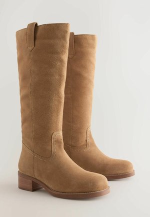 Tan suede knee-high boots with a rounded toe, block heel, and decorative stitching along the seams. Features a pull tab at the top.