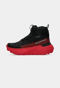 Zwarte en rode wandelschoen met een gestructureerde bovenkant, GORE-TEX-label, gewatteerde kraag, dikke zool en duurzaam vetersysteem.
