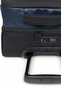 Maleta negra con ruedas, exterior de tela texturizada, detalles en azul, cremalleras dobles y un candado de combinación junto a un asa telescópica.