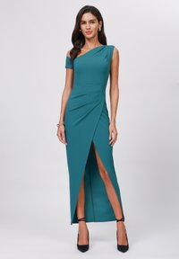 Teal off-shoulder dress with a fitted silhouette, draped side panel, and high slit. Made from a smooth fabric with a matte finish.
