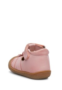 Rosa lädersandal med öppna sidor, justerbar rem och tanfärgad gummisula. Har en dekorativ rosett och mjuk textur.