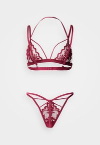 Μπουστάκι από δαντέλα σε μπορντό με κυματιστά άκρα και ρυθμιζόμενους ιμάντες, συνοδευόμενο από ένα ταίριαστο στρινγκ με περίτεχνη δαντελένια λεπτομέρεια.