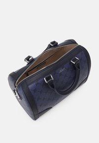 Sac à main bleu marine avec un motif en relief, des accents en cuir, des poignées doubles et une fermeture éclair, doté d'une doublure intérieure beige.