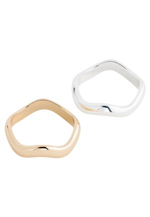 Two irregular pentagon-shaped rings, one in gold and one in silver, displayed on a white background.