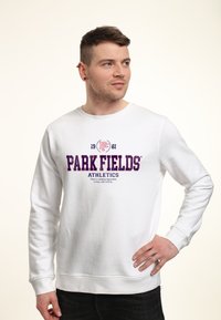 Sweatshirt blanc arborant "PARK FIELDS ATHLETICS" en texte bleu marine, col rond, manches longues et poignets côtelés. Tissu en mélange de coton.