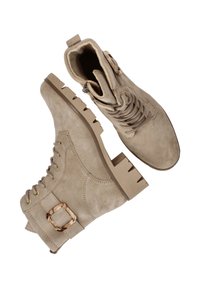 Beige suède enkellaarsjes met een chunky zool, vetersluiting aan de voorkant en een zijgesp accent. Voorzien van gestikte details en een gestructureerde afwerking.