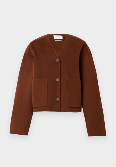 Veste en laine marron, courte, avec un col en V, trois boutons sur le devant et deux grandes poches à patch.