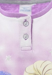 Lilac cotton shirt with gray trim, featuring two gray buttons at the neckline and a print of various characters and stars in lighter hues.