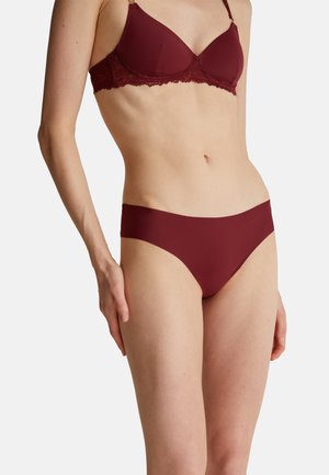 Ensemble de lingerie bordeaux comprenant un soutien-gorge rembourré rehaussé de dentelle et un slip seamless au design minimaliste et à la texture lisse.