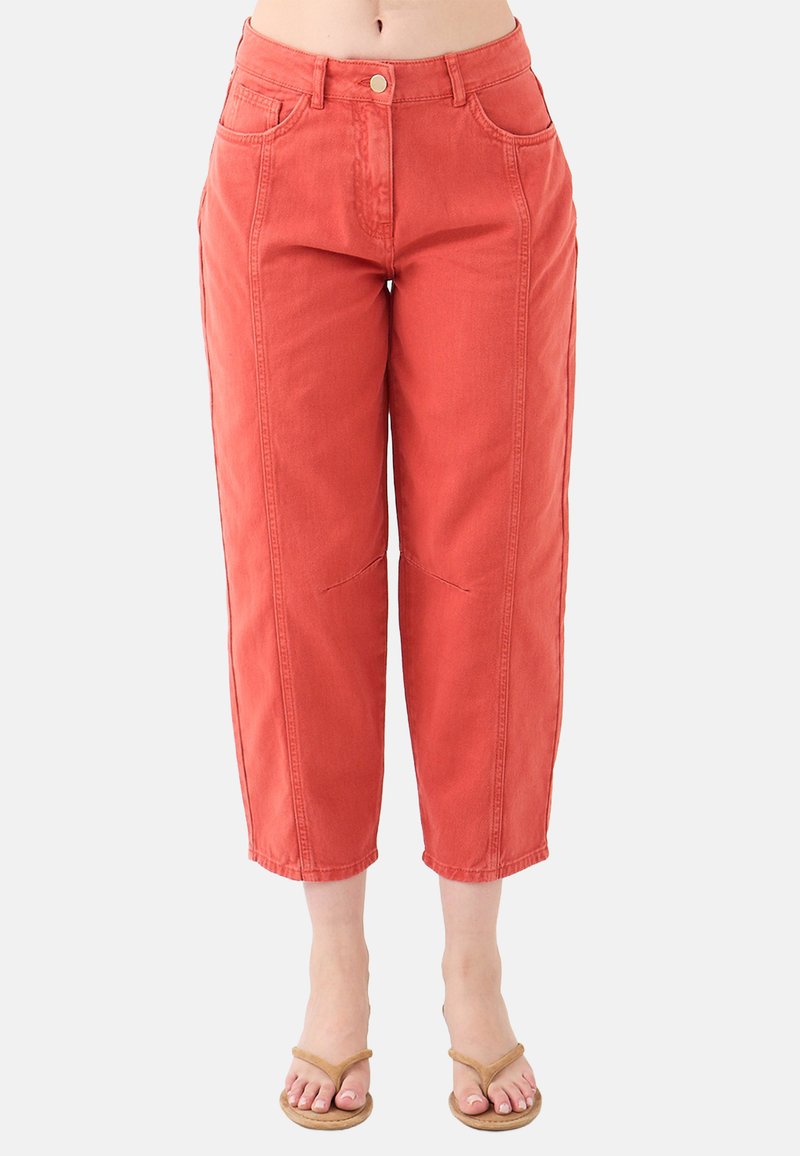 Pantaloni in denim color ruggine, cropped, con vita alta, chiusura frontale a bottone e dettagli di cucitura discreti sulle gambe.