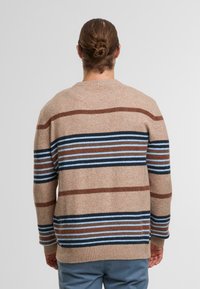Brązowy sweter w paski z pionowymi paskami w odcieniach niebieskiego i ciemnobrązowego, wykonany z teksturowanej dzianiny, z prążkowanym dołem i mankietami.