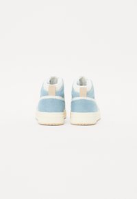 Tênis de cano alto azul claro com acabamento texturizado, colarinho acolchoado branco, sola de borracha creme e detalhe do calcanhar bege.