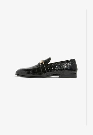 Mocasines de charol negro con un patrón de cocodrilo, diseño slip-on y un acento de hardware dorado en la parte delantera. Suela plana y forma estilizada.