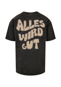 Grafisk sort t-shirt med teksten "ALLES WIRD GUT" i en beige, stiliseret skrifttype på ryggen. Standard crew neck design.
