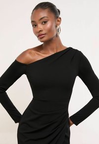 Melnā off-shoulder kleita ar pieguļošu dizainu, garām piedurknēm un drapējumu uz svārkiem, lai pievienotu tekstūru. Eleganta auduma izvēle.