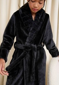 Black fleece robe with a plush, ribbed collar and matching belt. The fabric has a soft, luxurious texture and long sleeves.