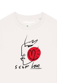 Weißes Baumwoll-T-Shirt mit einer minimalistischen Schwarzlinie Zeichnung eines Gesichts und einem roten kreisförmigen Akzent mit einem Herzen. Der Text lautet "SELBSLIEBE."