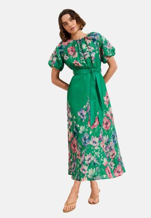 Rochie verde cu imprimeu floral, mâneci scurte bufante și talie legată. Prezintă modele vibrante de flori roz și albastre pe un material texturat.