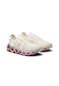 Scarpe da ginnastica beige chiaro con tomaia in maglia traspirante, suola in gomma rosa, dettagli testurizzati e lacci ton sur ton. Presentano un logo sul lato.