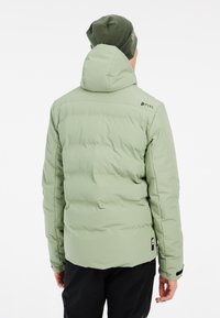 Hellgrüne Pufferjacke mit Kapuze, mit horizontaler Steppung, einem Logo auf der Schulter und schwarzen Akzenten an den Bündchen und am Saum.