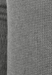 Tessuto a maglia grigio che mostra un motivo testurizzato con una superficie liscia. Il tessuto è di peso medio e ha punti uniformi e stretti.