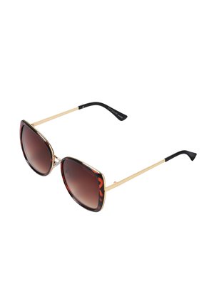 Lunettes de soleil en forme d'œil de chat avec une monture en écaille de tortue et des accents dorés, des verres dégradés marron foncé et des embouts de branche noirs.