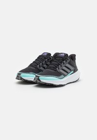 Zwarte sportschoenen met een gestructureerde mesh bovenkant, drie grijze strepen en turquoise accenten op de zool. Voorzien van een gewatteerde witte tussenzool.