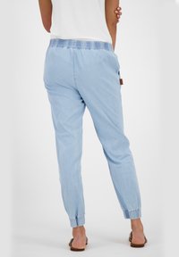 Jasnoniebieskie, lekkie spodnie z elastyczną talią i mankietami. Posiadają boczne kieszenie i luźny krój.