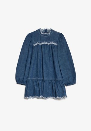Denimkjole med lange pufferm ermer, rund hals og hvit brodert bølget kant. Har en lagdelt volangkant nederst for ekstra detalj.