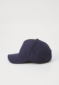 Casquette de base-ball navy en tissu doux, avec une visière incurvée, des détails cousus et des œillets de ventilation sur les côtés.