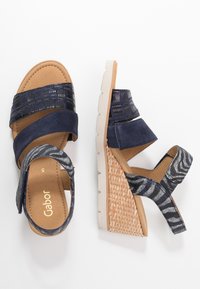 Námořnické wedge sandály s texturovanými námořnickými a vzorovanými popruhy, béžovou polstrovanou stélkou a wedge patou ve stylu espadrilles.