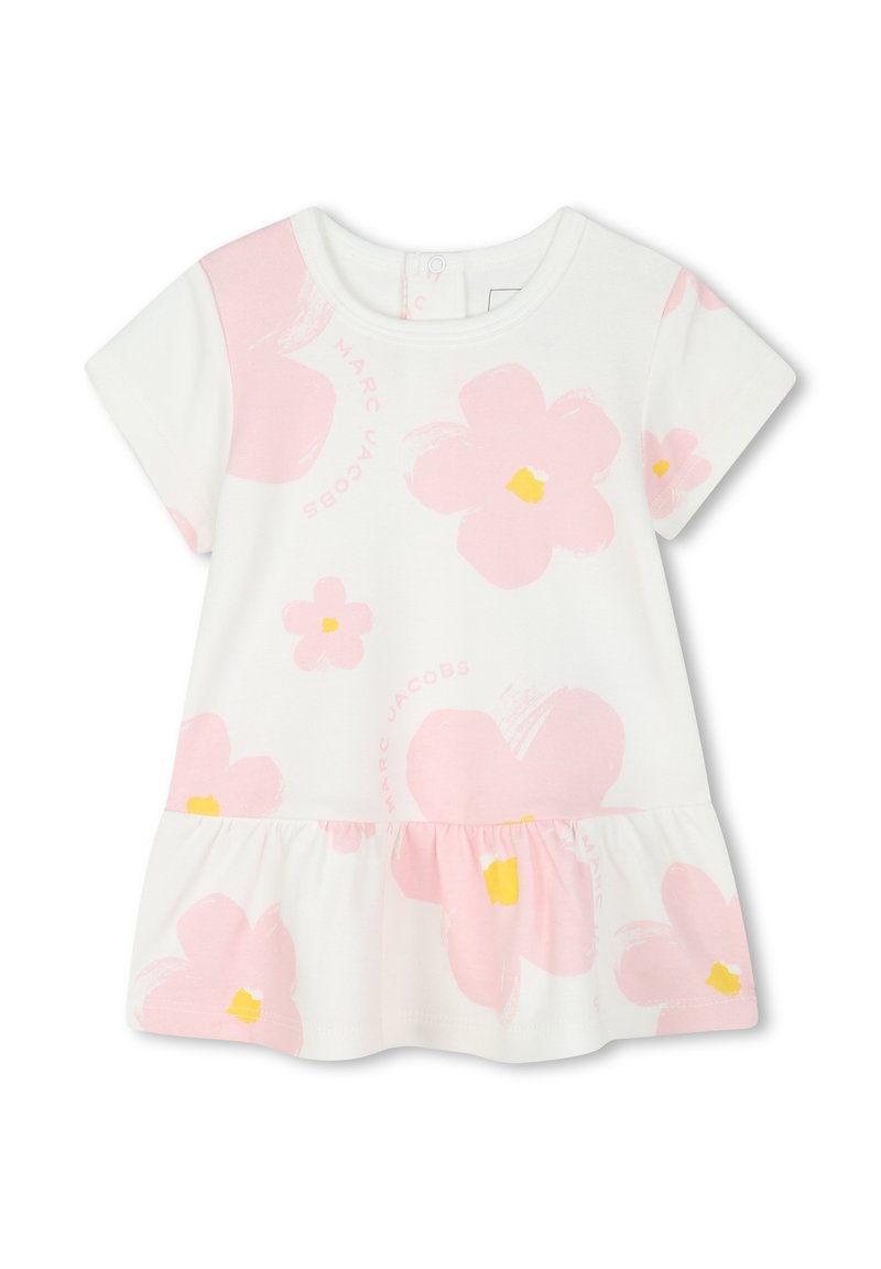 Abito bianco di cotone con maniche corte, caratterizzato da grandi motivi floreali rosa con centri gialli. L'orlo della gonna con volant aggiunge dettagli e texture.