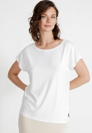 T-shirt bianco a maniche corte con vestibilità ampia e scollo largo, realizzato in tessuto morbido. Presenta un'etichetta discreta in basso a sinistra.
