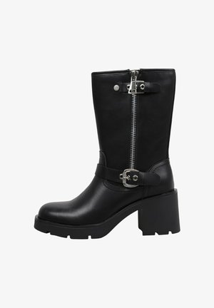 Botte noire en cuir jusqu'au milieu du mollet avec talon épais, fermeture éclair latérale et sangles décoratives à boucle autour de la cheville et près du haut.