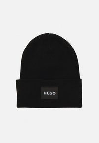 Μαύρο πλεκτό σκουφάκι με διπλωμένο γύρισμα και ορθογώνια μαύρη ετικέτα που προβάλλει με λευκό κείμενο "HUGO".